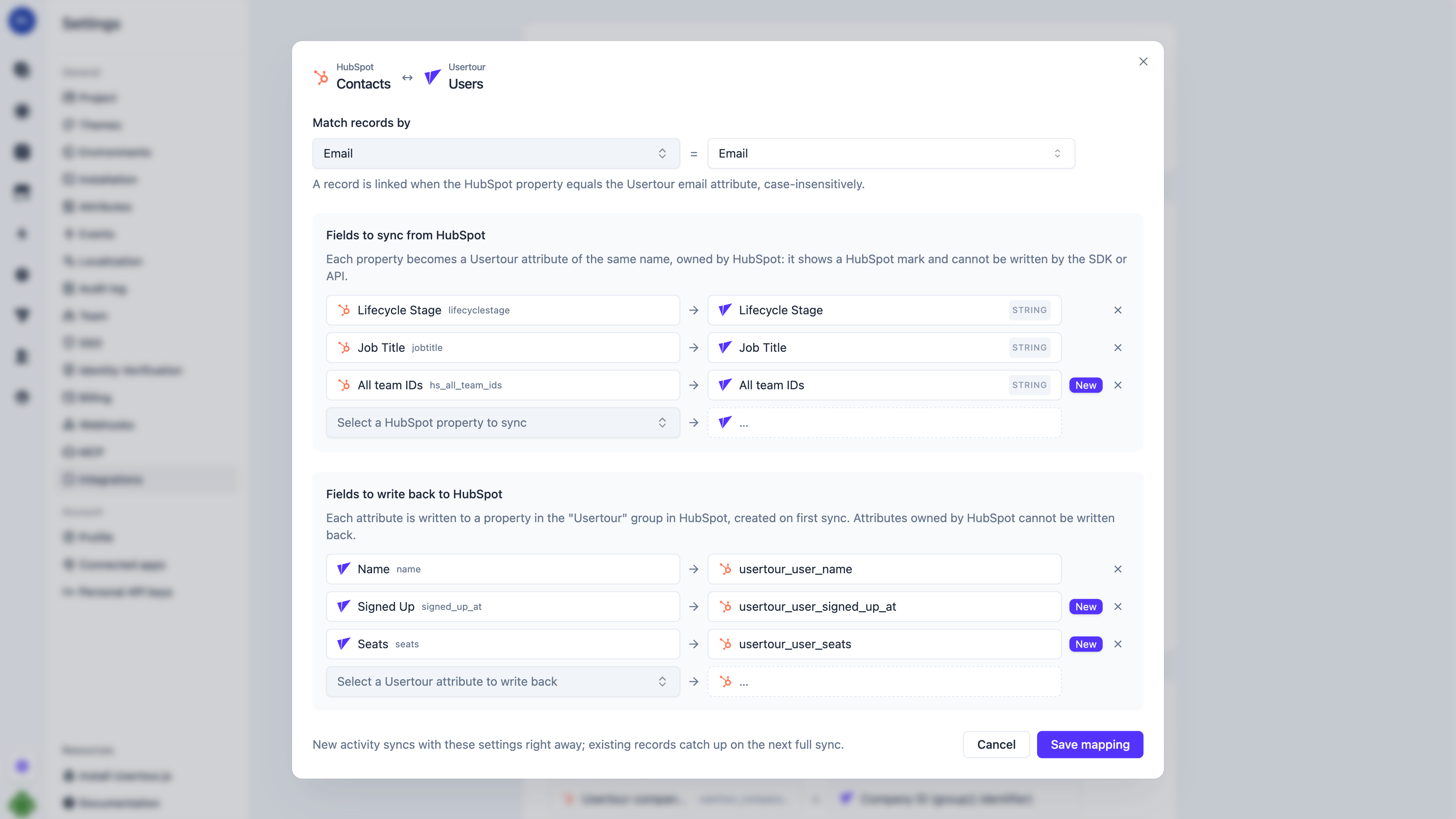 The mapping editor: HubSpot contact properties paired with Usertour user attributes in both directions